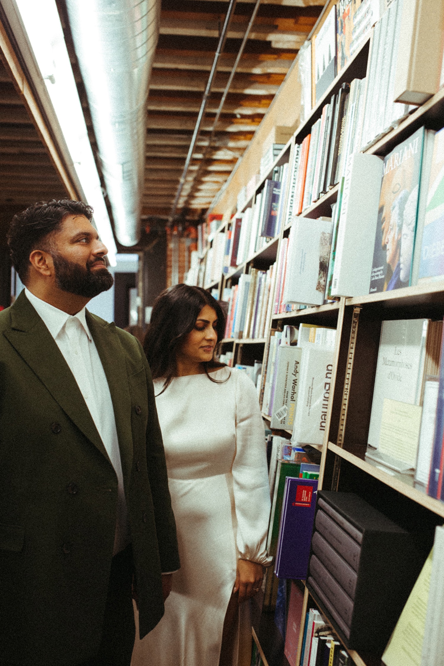 Couple walking in bookstore during their engagement photos in Los Angeles.