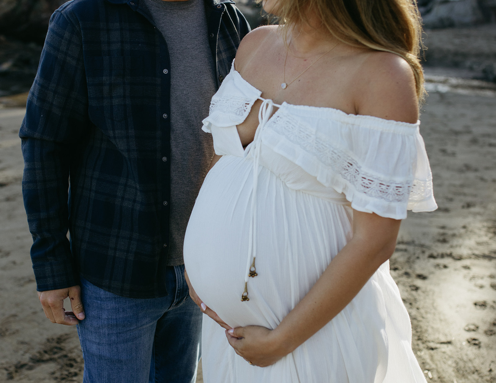 Couple pose for maternity photos at beach in Bay Area