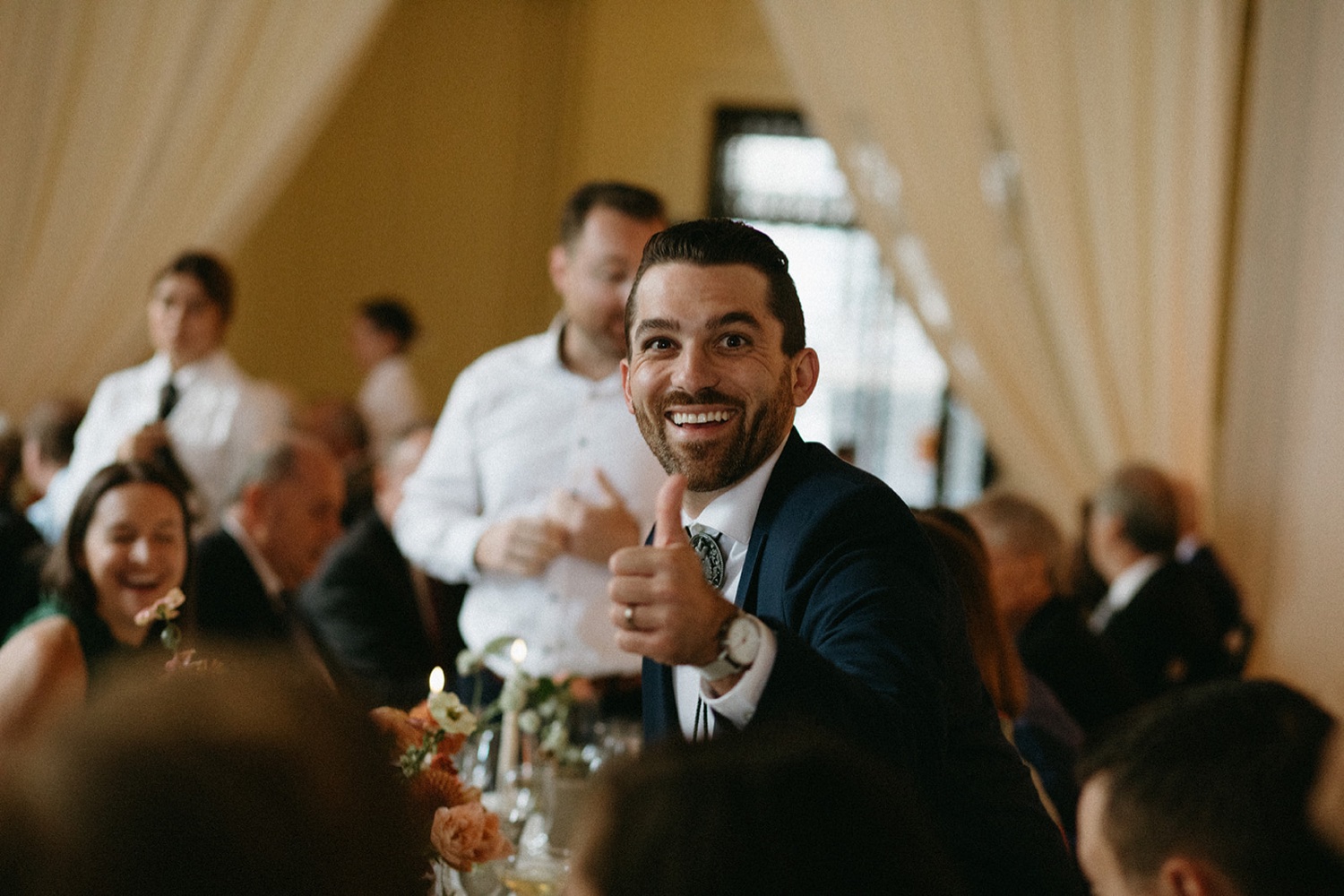 Guest gives thumbs up at wedding reception in San Francisco