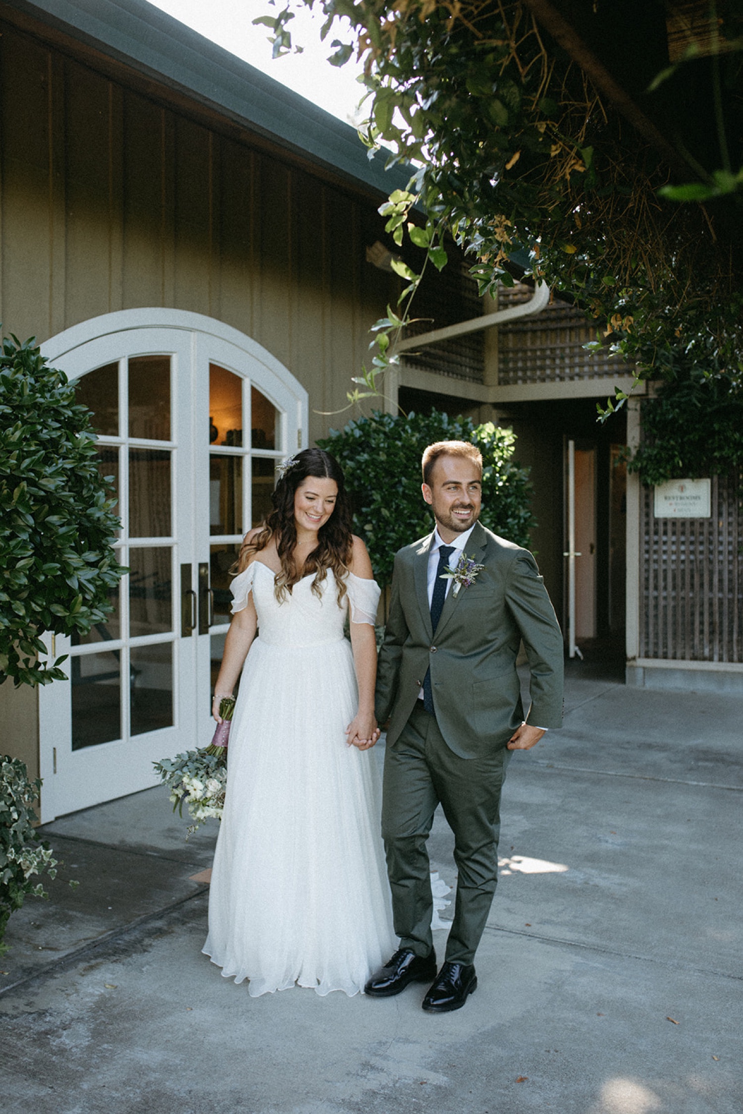 Bride and groom hold hands on their wedding day in Napa