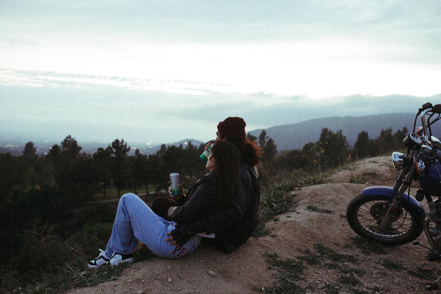 Couple with motorcycle sit with a view