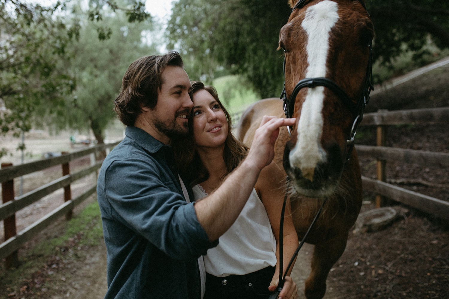 Couple pose with horse for their engagement session.