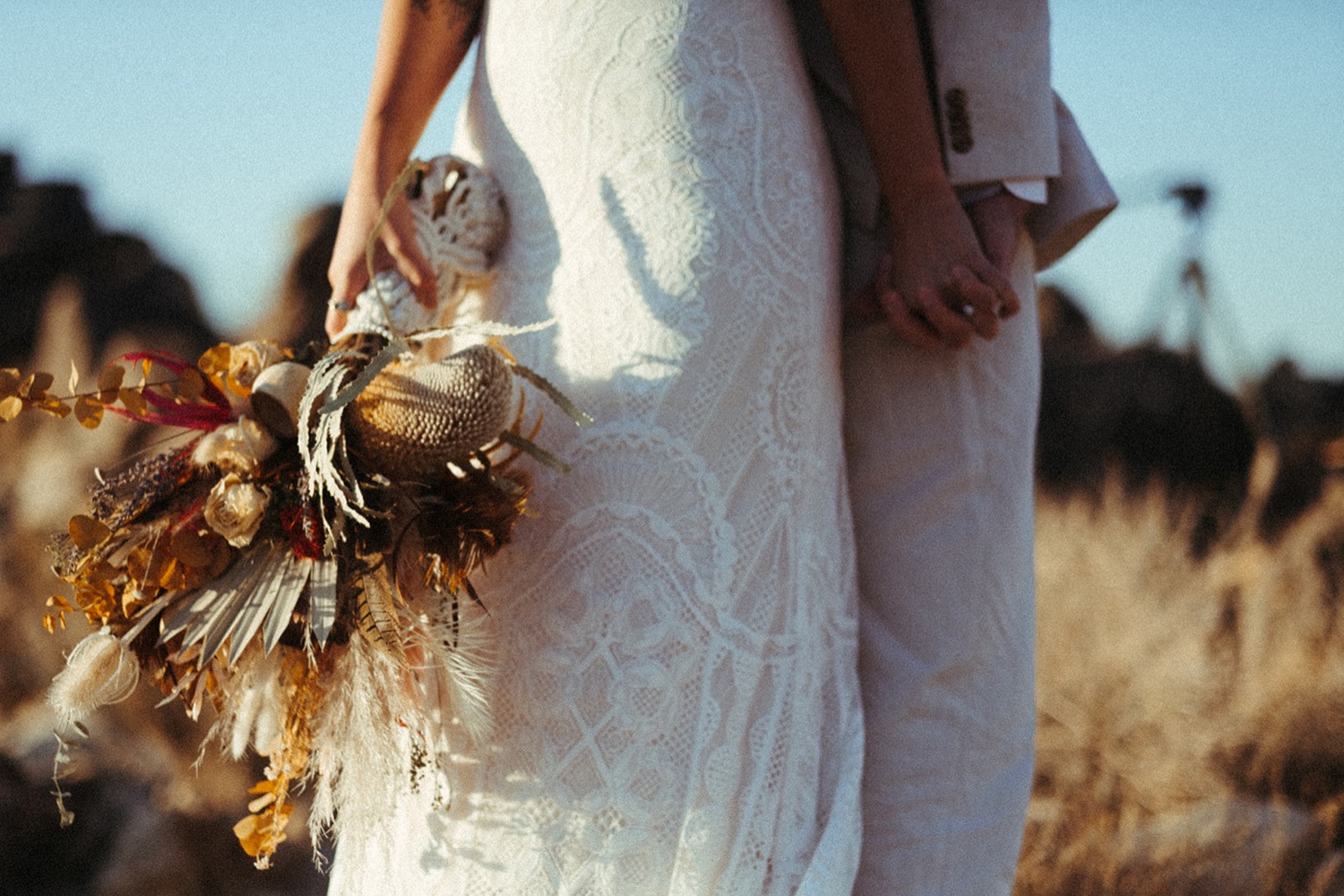 Bride and groom hold hangs during their desert wedding day in Joshua Tree.