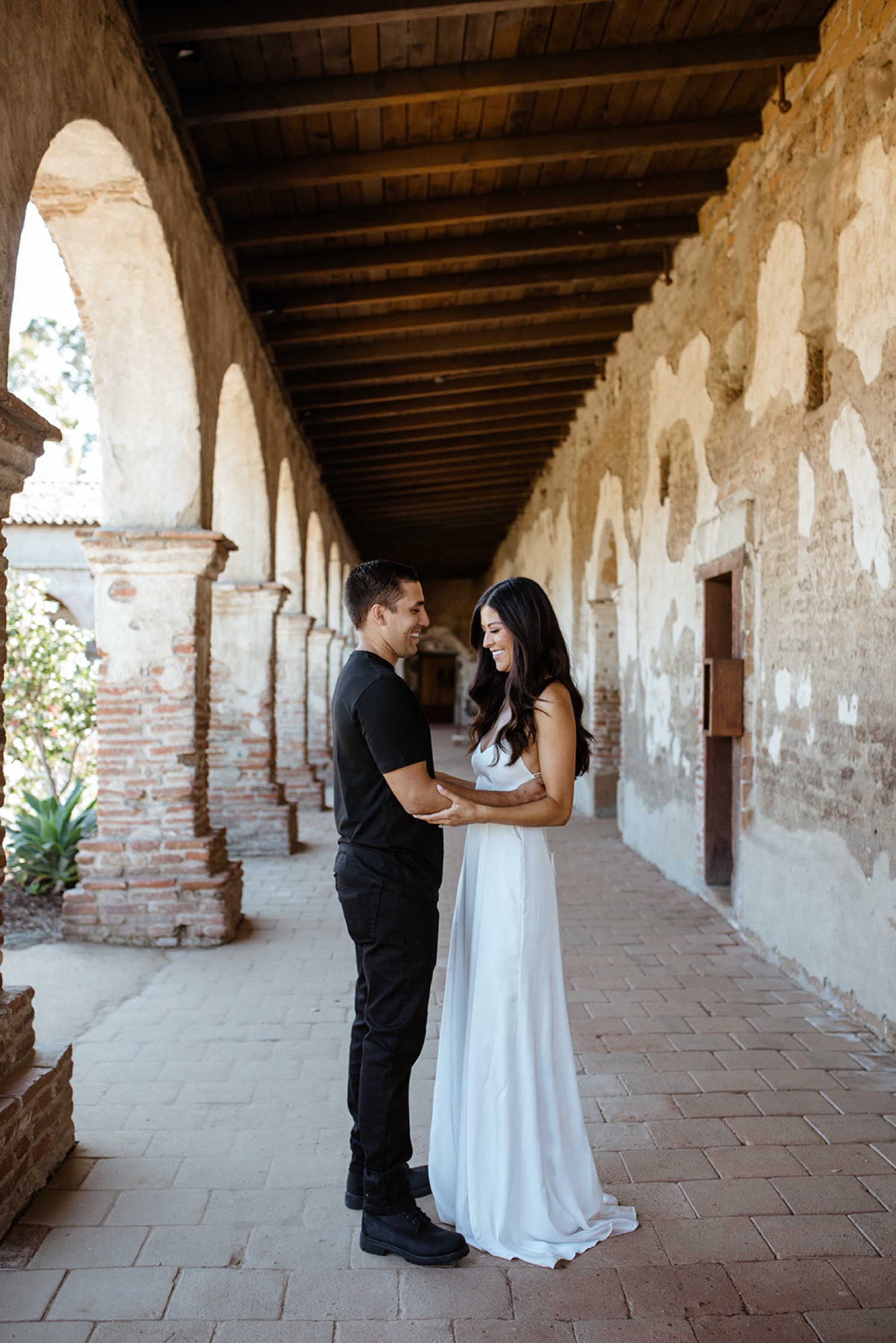 Couple embrace during their engagement session at San Juan Capistrano.