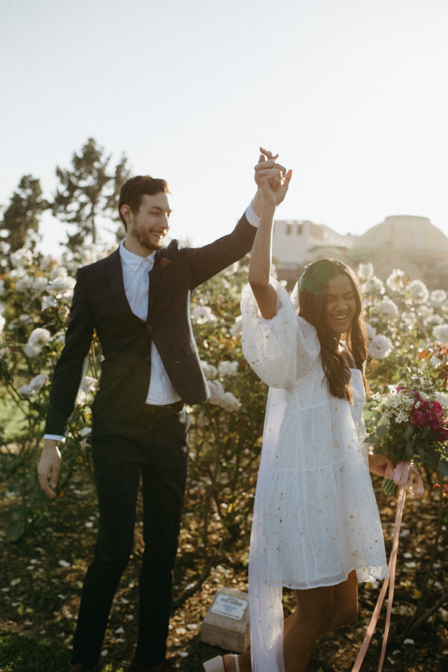 Couple dance in a rose garden during their engagement photos in Los Angeles.