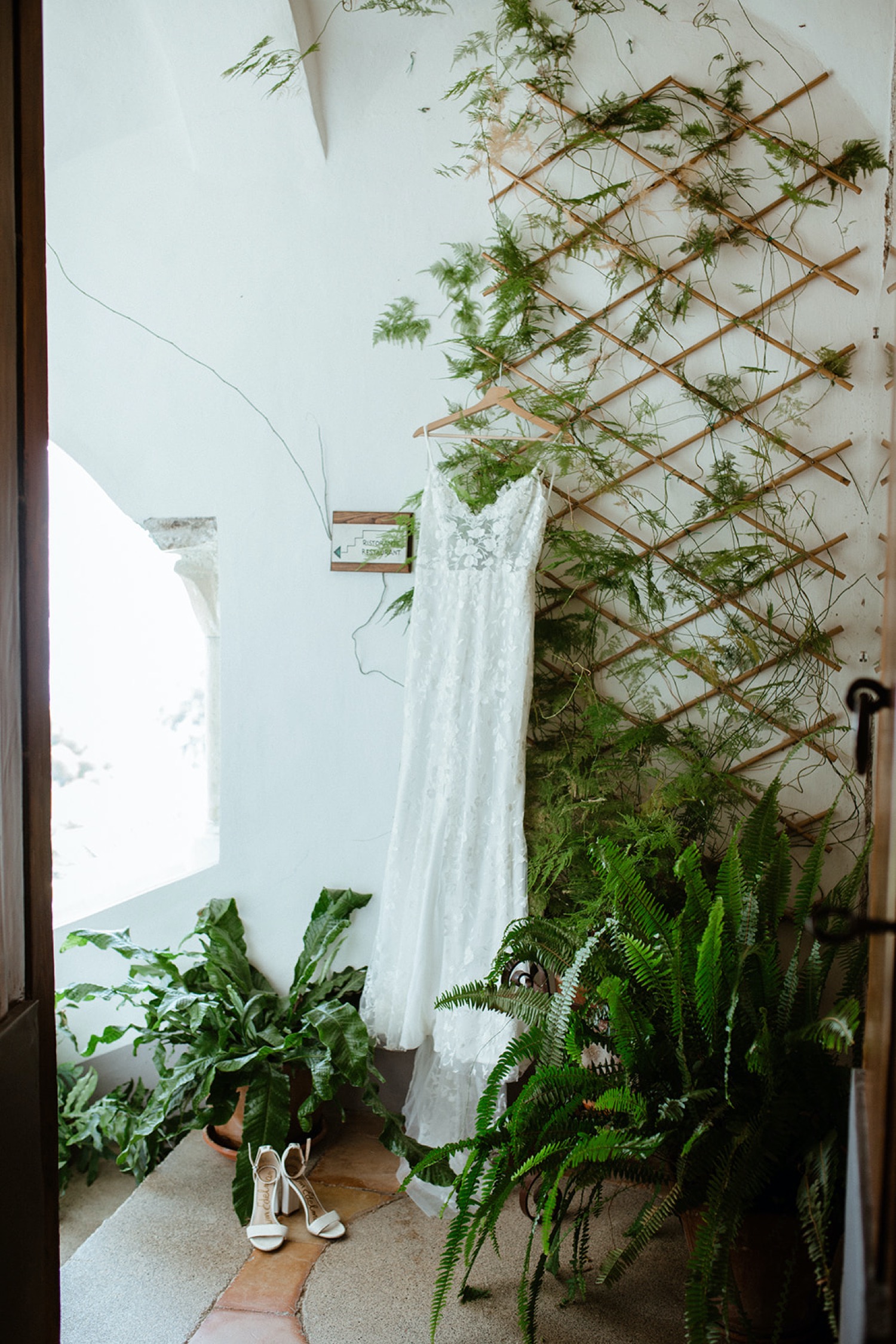 A wedding dress hangs in hotel on wedding day in Amalfi, Italy.