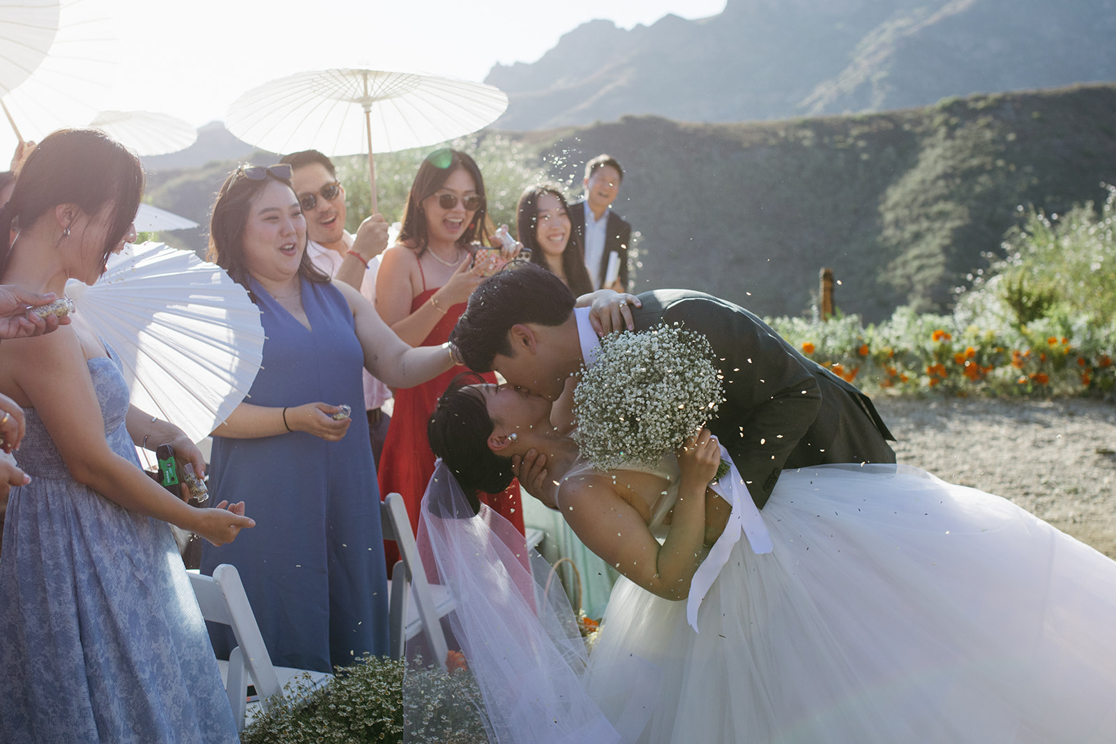 Bride and groom kiss in front of their wedding guests